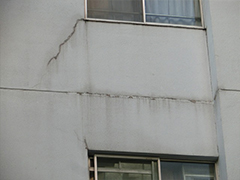 外壁のひび割れ補修跡(窓枠付近)。階間のシーリング劣化。
